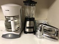 Photo showing Mr. Coffee drip coffee maker, Hamilton Beach blender, and Cuisinart hand mixer together on counter