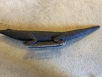 Top-down angled view showing the length and side texture of the carved wooden caiman.