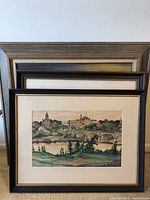 Front view of three framed art pieces stacked showing two watercolors and one oil on canvas