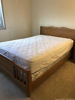 View of the full bed frame with mattress inserted, showing headboard, side rails, and mattress.