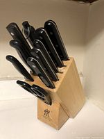 Front angled view of Zwilling knife block holding knives and scissors with black handles.