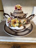 Full view of the Capodimonte porcelain soup terrine with lid and floral decorations on a matching plate.