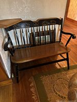 Full view of bench showing arrowback spindles, contoured seat, and side table.