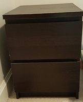 Front view of dark espresso bedside table with two drawers slightly open showing drawer function.