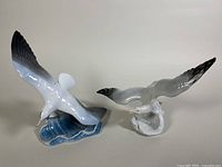 Two porcelain seagull statues together viewed from side showing sizes, colors, and bases