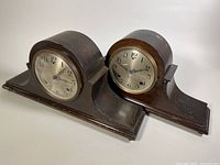 Two vintage Sessions mantle clocks side by side showing full bodies and clock faces, wooden cases with some wear.