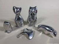 Group photo showing all five aluminum animal sculptures together on a neutral surface under diffuse lighting.