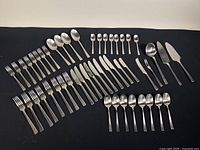 Full spread of all flatware pieces laid out on black cloth