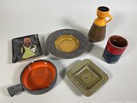 All six pottery items arranged together showing variety of shapes and colors.