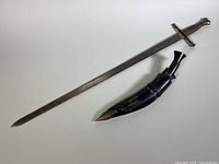 Full view of Charles V replica sword next to its scabbard on a plain background.
