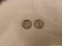 Obverse side of two Canadian silver quarters from 1907 and 1910 showing King Edward VII portraits.