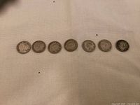 Front side of seven Canadian silver dimes featuring King George VI from the years 1940, 1941, 2x 1943, 1945, 2x 1951.