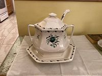 Large Adams Lincoln ironstone tureen with lid, two handles, green floral pattern, and ribbed detail, sitting on matching underplate with ladle inside tureen