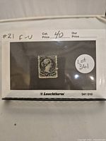 Photo of the 1/2 cent black Queen Victoria stamp mounted in protective sleeve marked with catalog number 21 and price $40.