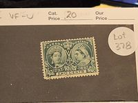 Close-up photo of single green Canadian postage stamp issued in 1897 featuring Queen Victoria portraits for Jubilee issue.