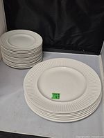 Stack of 6 larger dinner plates (10 inches) and 16 smaller side plates (6 inches) displayed on a table.