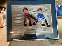 Front view of framed primitive style painting showing two ice skaters on an icy surface with brown and blue clothing.