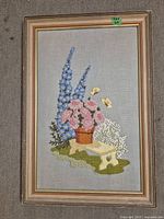 Full view of needlework picture in frame showing entire floral and butterfly composition.
