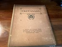 Front cover of the large hardcover book titled 'Oh! Canada'. Beige cover with printed black text and a maple leaf emblem.