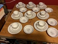 Full set showing 8 cups with saucers, 8 salad plates, 7 bread plates, and 6 fruit nappies arranged on table.
