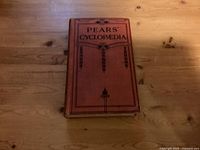 Front cover of Pears' Cyclopaedia showing title and decorative elements on orange background.