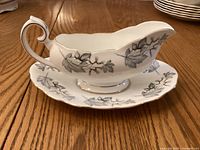 Gravy boat with silver maple leaf design and gold trim.