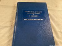 Blue hardcover book titled 'Stormont, Dundas and Glengarry A History' by John Graham Harkness, K.C., showing cover condition and title