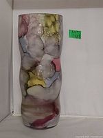 Front view of the tall art glass vase showing abstract multicolor design and slight vertical shape variation.