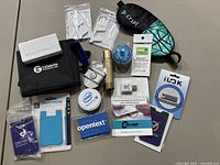 Photo showing all items laid out in a flat arrangement on a table, featuring black Cellbrite pouch, Cribl sleep mask, several USB blockers and promotional patches.