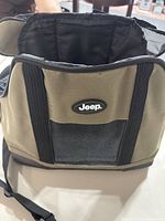 Front view of Jeep brand dog carrier showing the olive green and black exterior with Jeep logo.