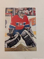 Front of Jose Theodore rookie card showing goalie in red Canadiens jersey with gold Pinnacle branding.