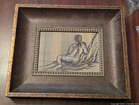 Wide view of the framed nude figure painting, showing frame and inset painting with border details.