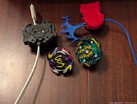 Top view of two Beyblade figures with their launchers on a wooden surface