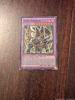 Front image of Yu-Gi-Oh Dark Paladin trading card on a wooden surface, showing significant wear indicative of heavy play.