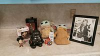 Entire lot of Star Wars and pop culture collectibles including boxed and loose figures, Uno game, and framed photo.