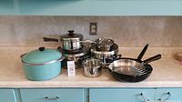 View of entire set with pots and pans of various sizes and materials on countertop.