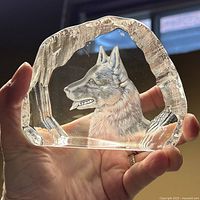 Front view held against a window showing the transparency and detailed etching of the German Shepherd dog's head in clear crystal glass sculpture.