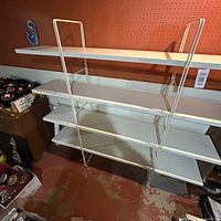 Front view of fully assembled shelving unit against pegboard wall