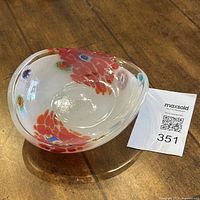 Image showing angled top view of the triangular Italian opaline white glass bowl with red and blue millefiori floral patterns inside.