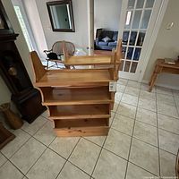 Pair of wooden rustic Anderson International Ltd. bookshelves placed side by side on tiled floor near door.