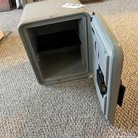 Image showing the safe with the door open, revealing single interior shelf and empty storage compartment.