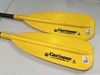 Close-up of two yellow Caviness canoe paddle blades showing brand name and length sticker 4.5 ft.