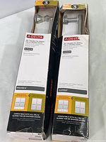 Two unopened, weathered boxes of Delta shower door handles showing brand and product details on packaging