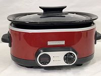 Front view of KitchenAid 7-quart slow cooker crockpot in red and black with control dial and indicator light on front.