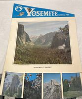 Full view of laminated Yosemite National Park poster with large central image of Yosemite Valley and smaller images below in a blue header.
