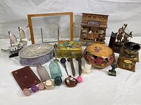 Overview of the entire lot showing various collectible and decorative items including wooden ship models, glass bottles, decorative boxes, and small figurines.