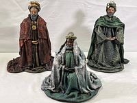 Three wise men figurines displayed on a plain surface with white background, showing overall condition and scale