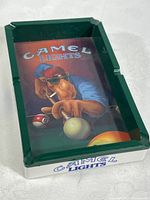 Top angled view of rectangular green ashtray showing Joe Cool camel graphic playing billiards, Camel Lights text on interior and side edge.