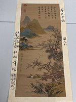 Full view of the vintage Chinese print scroll showing mountainous landscape, river, boat, trees, Chinese calligraphy, and red seals.