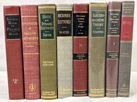 Full view of all 8 vintage textbooks standing upright, showing spines with titles in physics, electricity, electronics, microwave, electromagnetic and optic theory.